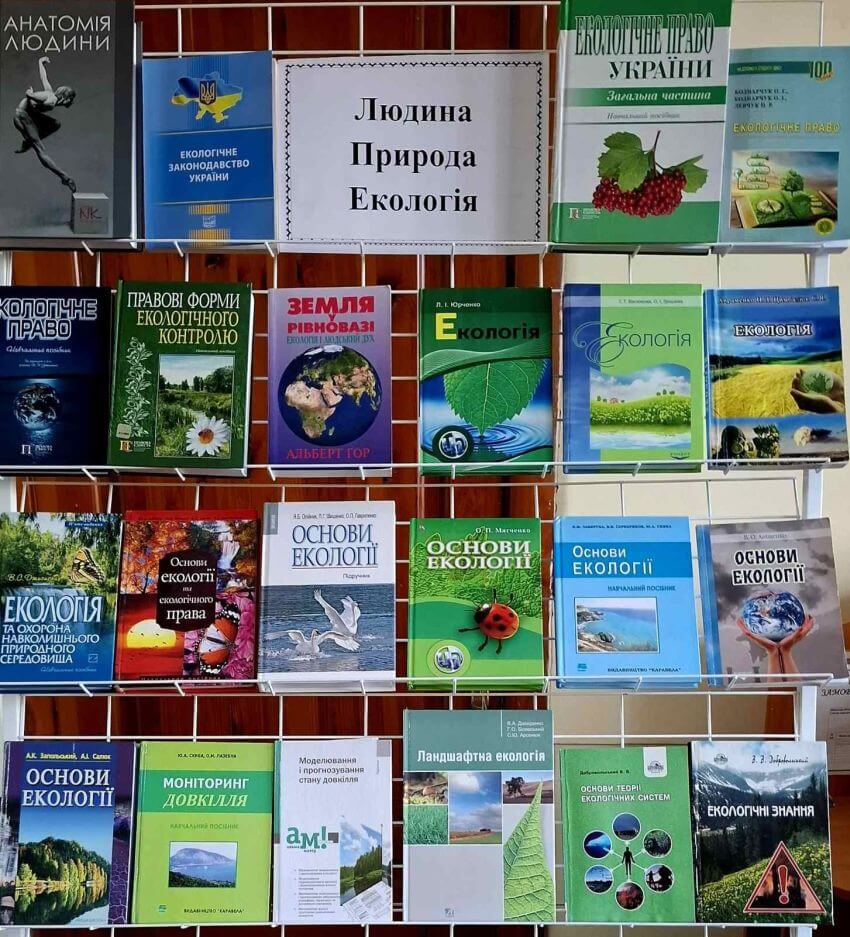 Фотографія стенда з книгами про екологію. Серед видань — «Екологічне право України», «Основи екології», «Земля у рівновазі» Альберта Гора, «Ландшафтна екологія» та «Моніторинг довкілля». У центрі верхнього ряду — табличка з назвою виставки: «Людина, Природа, Екологія». Книги мають яскраві обкладинки із зображеннями природи, планети та рослин