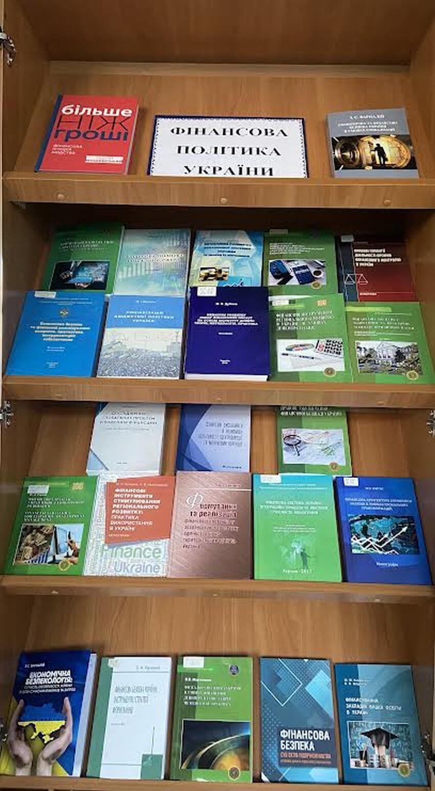 Фото книжкової полиці з експозицією «Фінансова політика України». На полицях представлено понад 20 наукових видань, підручників та монографій у різнокольорових обкладинках, присвячених економіці, фінансам та державній політиці